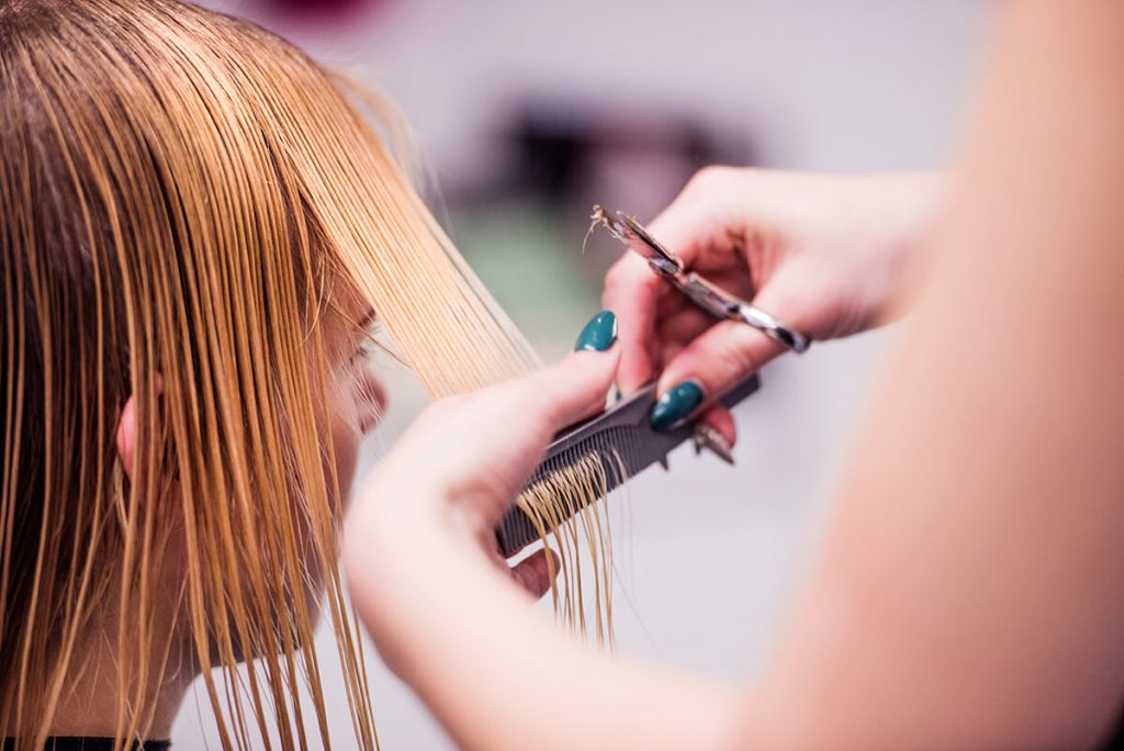 Hairstylist giving a woman a haircut in a hair salon